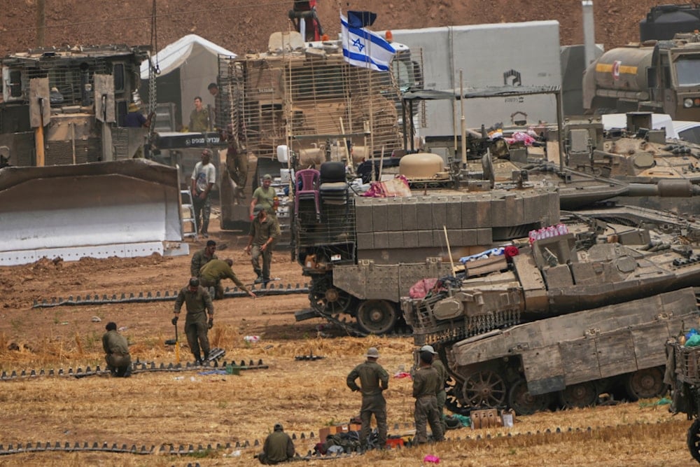 Israeli soldiers work on tanks and APCs at a staging area near the border with the Gaza Strip, in southern Israel, Thursday, May 15, 2025 (AP)