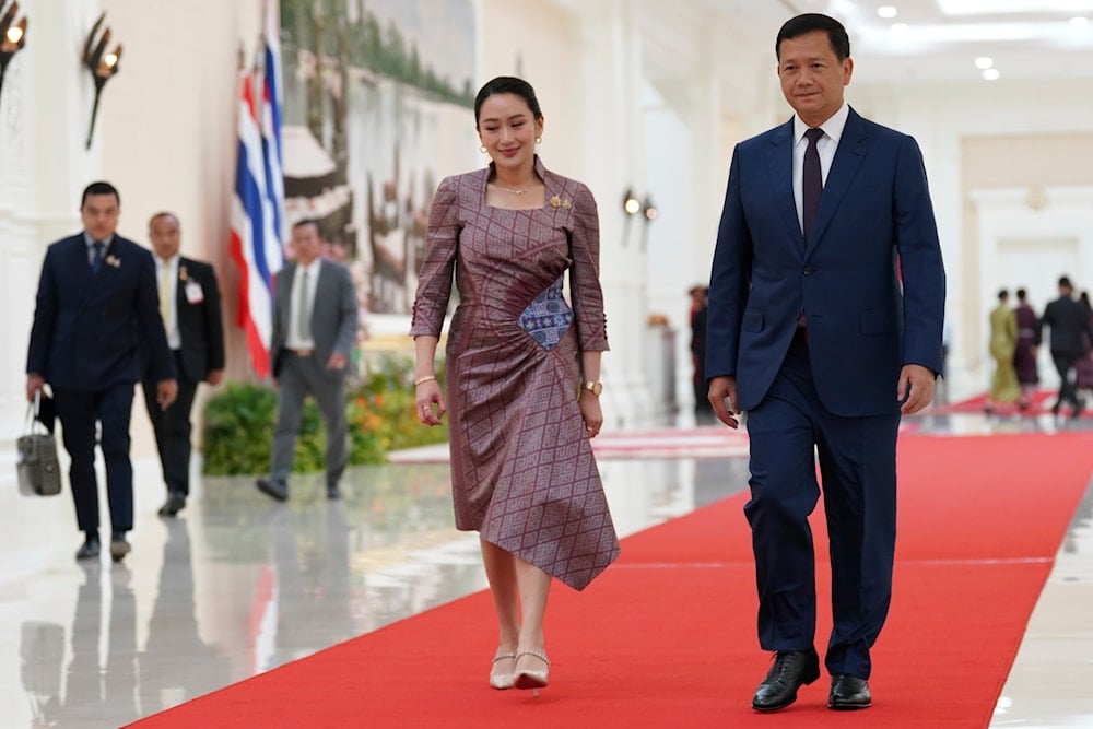 Thailand Prime Minister Paetongtarn Shinawatra, center, accompanied by Cambodian counterpart Hun Manet, right, arrives for a meeting at Peace Palace in Phnom Penh, Cambodia, April 23, 2025 (AP)