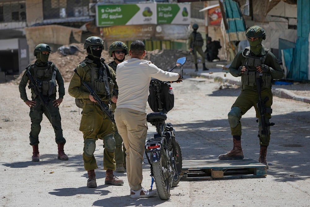 Israeli soldiers checked IDs of Palestinians returning to Tulkarem’s evacuated refugee camps on May 29, 2025, to collect belongings ahead of home demolitions (AP)