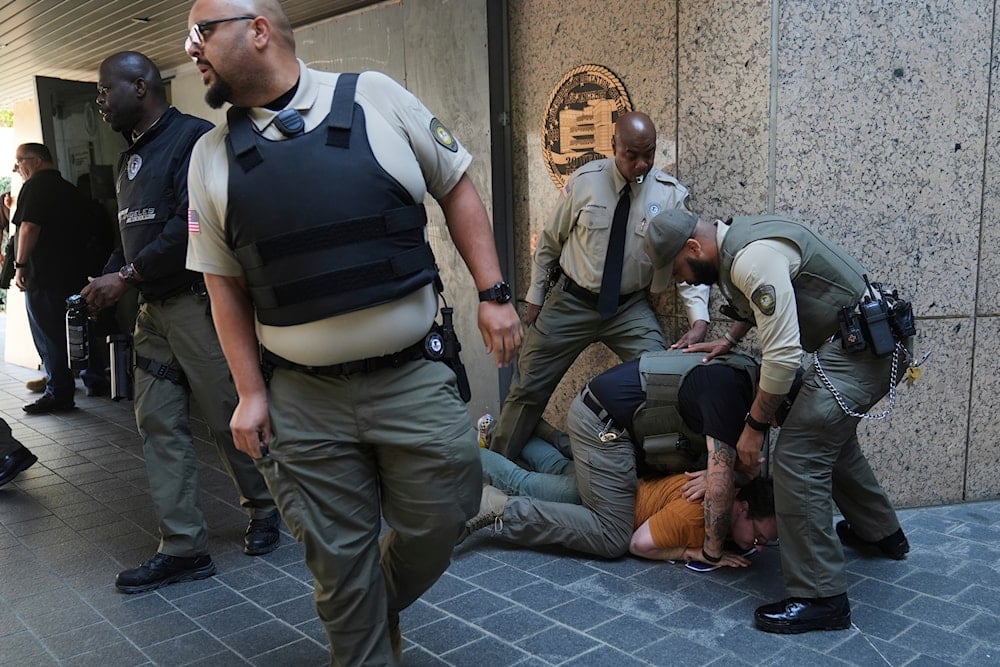 Law enforcement detain a protester at the U.S. Department of Justice Federal Bureau of Prisons after federal immigration authorities conducted an operation on June 6, 2025, in Los Angeles. (AP Photo/Jae C. Hong)