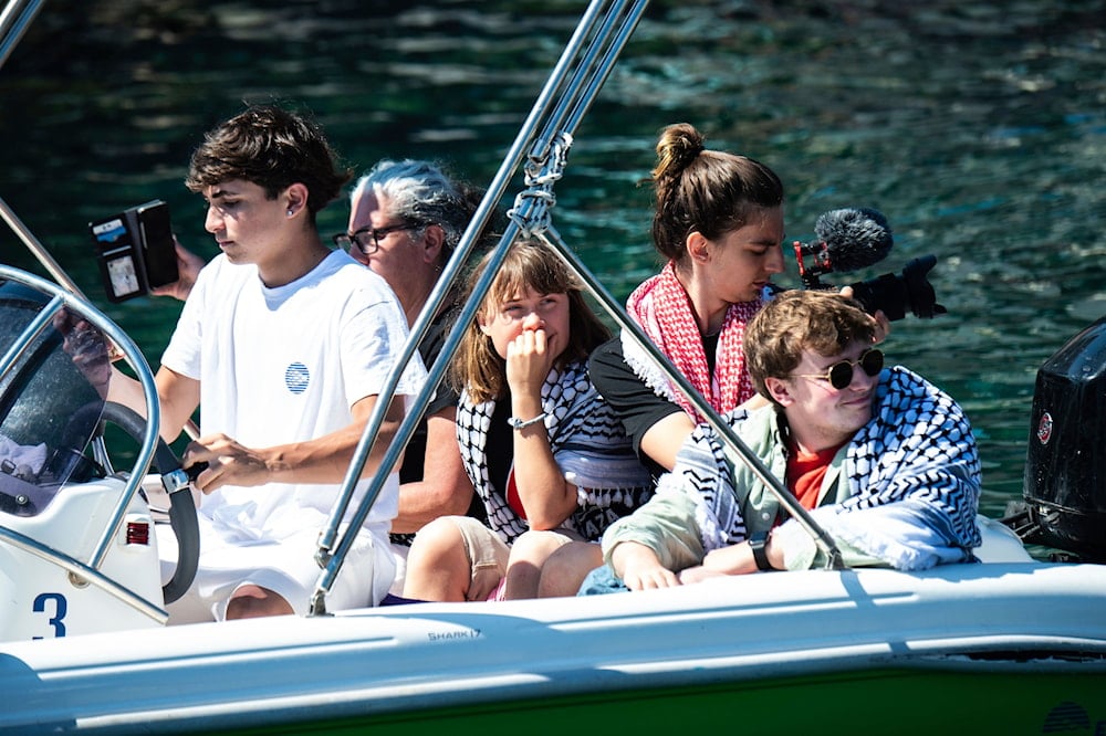 Climate activist Greta Thunberg, center, waits to board the Madleen boat, before setting sail for Gaza along with activists of the Freedom Flotilla Coalition, departing from the Sicilian port of Catania, Italy, Sunday, June 1, 2025 (AP)