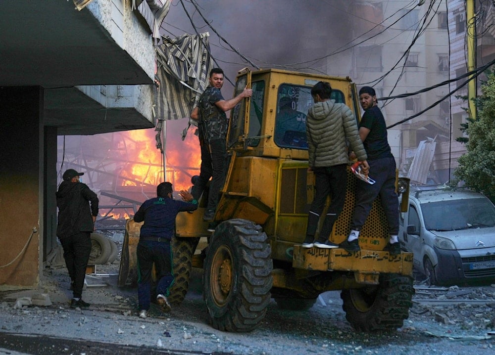 A bulldozer arrived to remove debris as flames rise from a metal tent that was hit by an Israeli airstrike on Dahiyeh in the southern suburb of Beirut, Lebanon, Sunday, April 27, 2025 (AP)