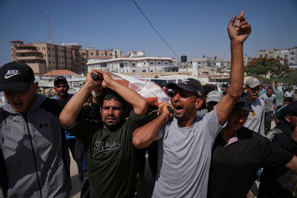 Palestinians carry the body of Ahmed Abu Hilal, who was killed while on his way to an aid hub in Gaza, during his funeral in Khan Younis, in the southern Gaza Strip, on Sunday, June 8, 2025 (AP)