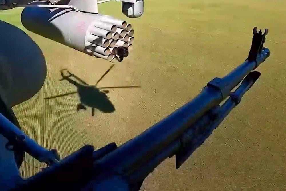In this photo taken from video distributed by the Russian Defense Ministry Press Service on Monday, May 19, 2025, a Russian Army soldier controls an area from a board of a military helicopter in an undisclosed location in Ukraine (AP)