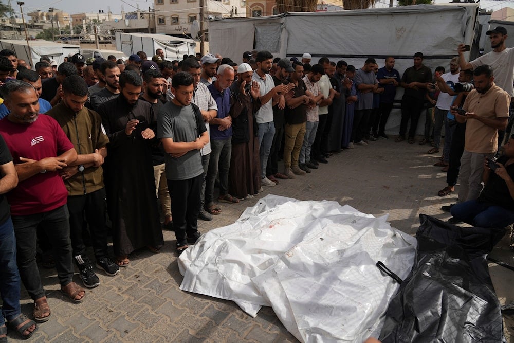 Mourners attend the funeral of members of Al-Aimawi family who were killed in an Israeli bombardment of Al-Zawaideh, at Al-Aqsa Hospital morgue in Deir al-Balah, Gaza Strip, on Tuesday, July 1, 2025 (AP)