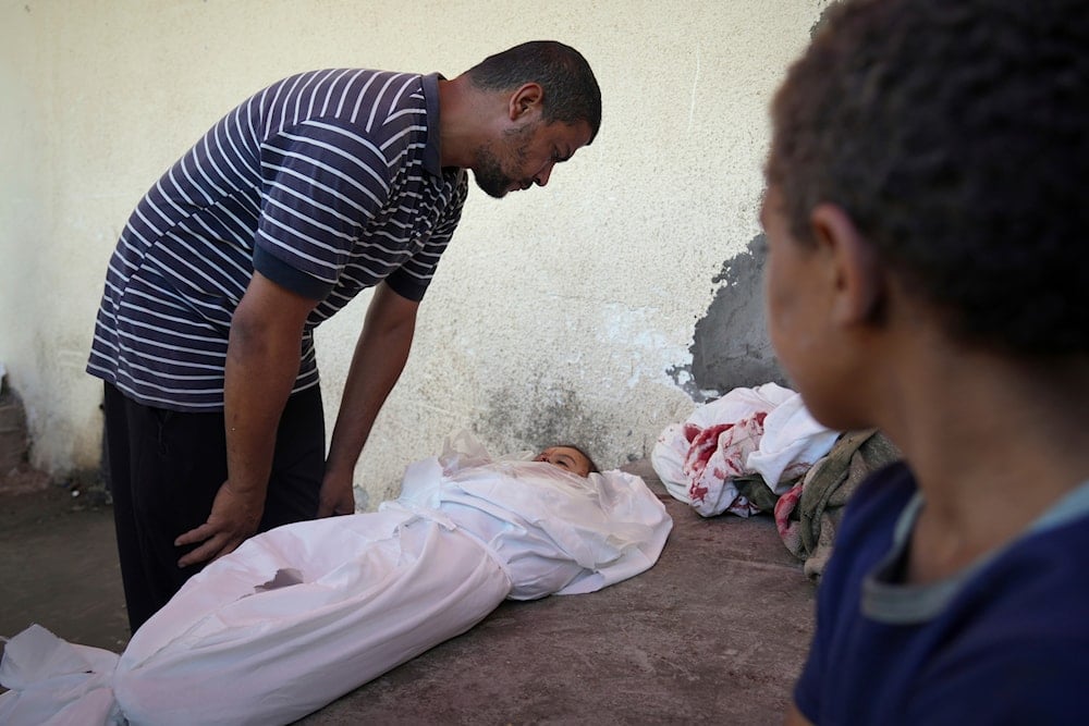 Omar Meshmesh looks at the body of his 3-year-old niece Aya, who was killed in an Israeli strike while waiting to receive nutritional supplements at a Project Hope-run medical clinic in Deir al-Balah, Gaza Strip, Thursday, July 10, 2025. (AP)