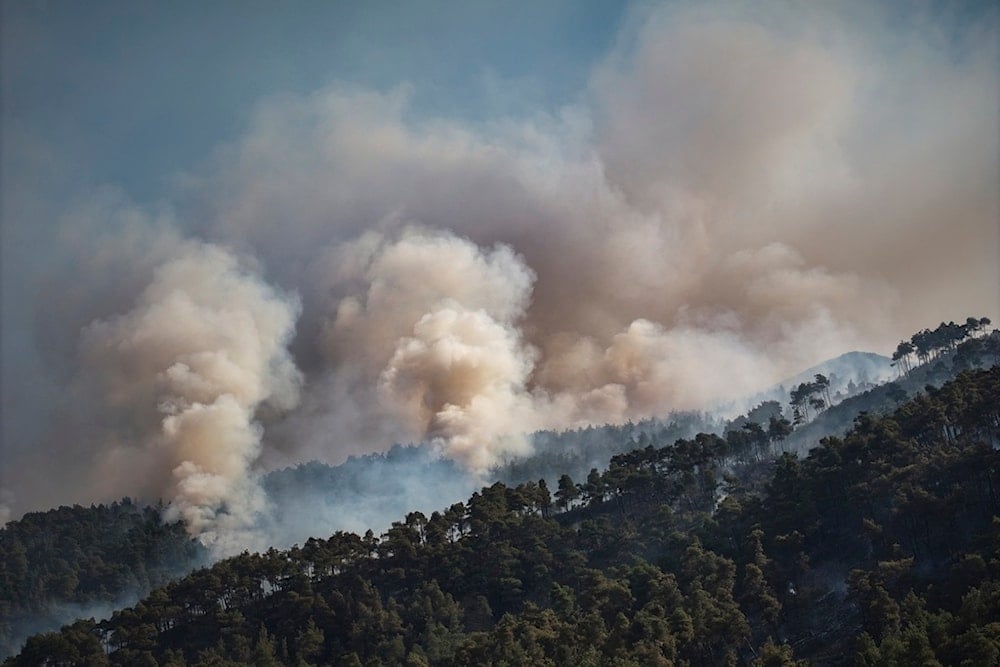 Smoke rises into the sky on the fifth consecutive day of a wildfire near the town of Rabia, Syria, in the Latakia countryside, Monday, July 7, 2025 (AP)