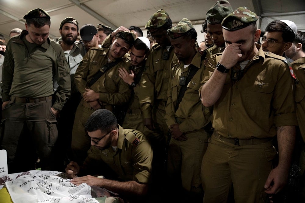 Israeli Occupation Forces soldiers mourn at the grave of Sgt. First Class Roi Sasson, who was killed in action in the Gaza Strip, during his funeral, Occupied al-Quds, Occupied Palestine, Wednesday, Nov. 20, 2024 (AP)