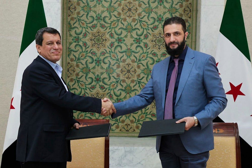 Syria's interim President Ahmad al-Sharaa, right, shakes hands with Mazloum Abdi, the commander of the US-backed Kurdish-led Syrian Democratic Forces, in Damascus, Syria, Monday, March 10, 2025 (AP)