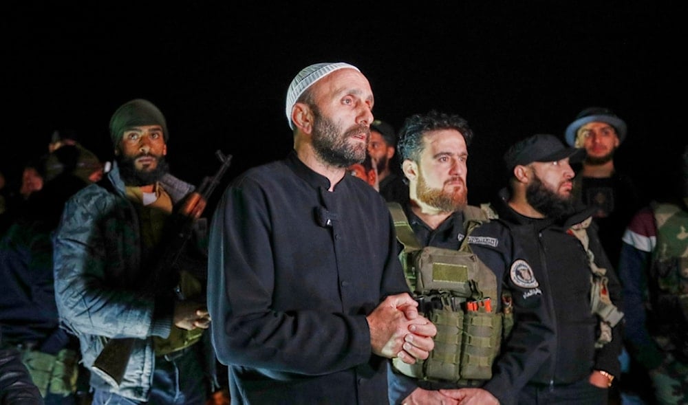 A Druze man, center, stands next to Syrian security forces who reached a deal with Druze gunmen to deploy around the southern Damascus suburb of Jaramana that has witnessed fighting earlier this week in Damascus, Syria, May 2, 2025. (AP)
