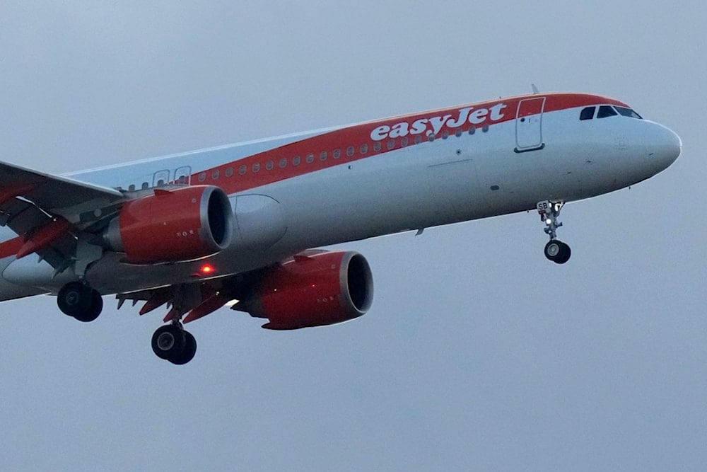 An easyJet airlines Airbus A321 approaches for landing in Lisbon at sunset, Tuesday, June 13, 2023. (AP Photo/Armando Franca)