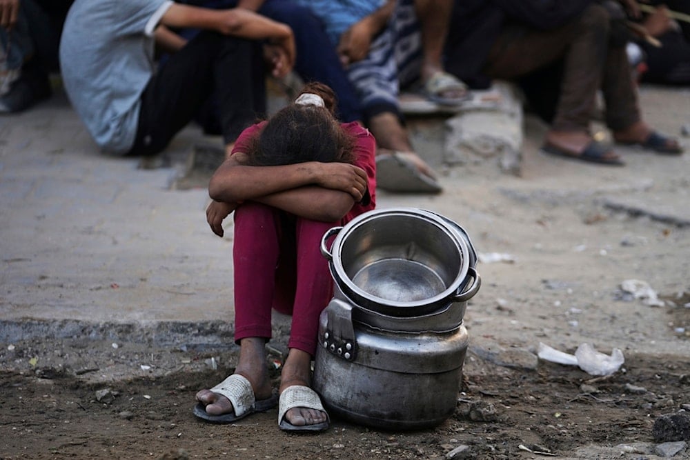 Palestinians wait for donated food at a community kitchen in Gaza City, in the northern Gaza Strip, Monday, July 14, 2025. (AP Photo/Jehad Alshrafi)