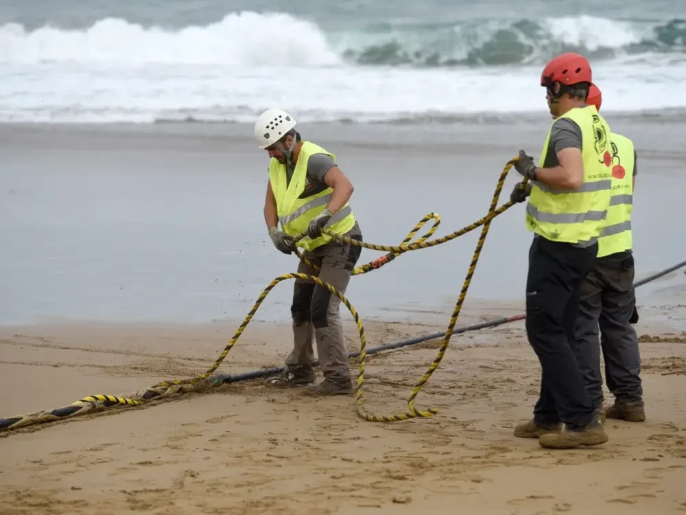 Operators handle an undersea fiber optic cable, undated (AFP)