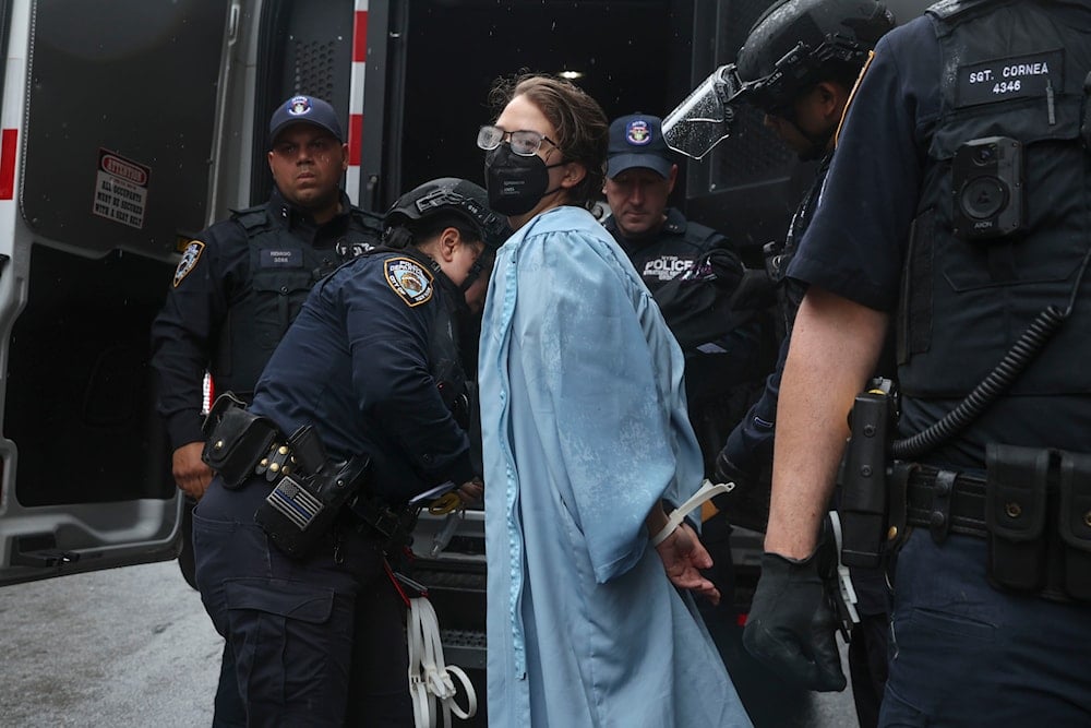 A person wearing graduate robes is detained by police across the street from the main gates of Columbia University, Wednesday, May 21, 2025, in New York. (AP)