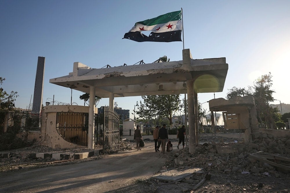 Security members carry belongings as they leave the damaged Syrian Defense Ministry building hit by several Israeli airstrikes, in Damascus, Syria, Wednesday, July 16, 2025 (AP)