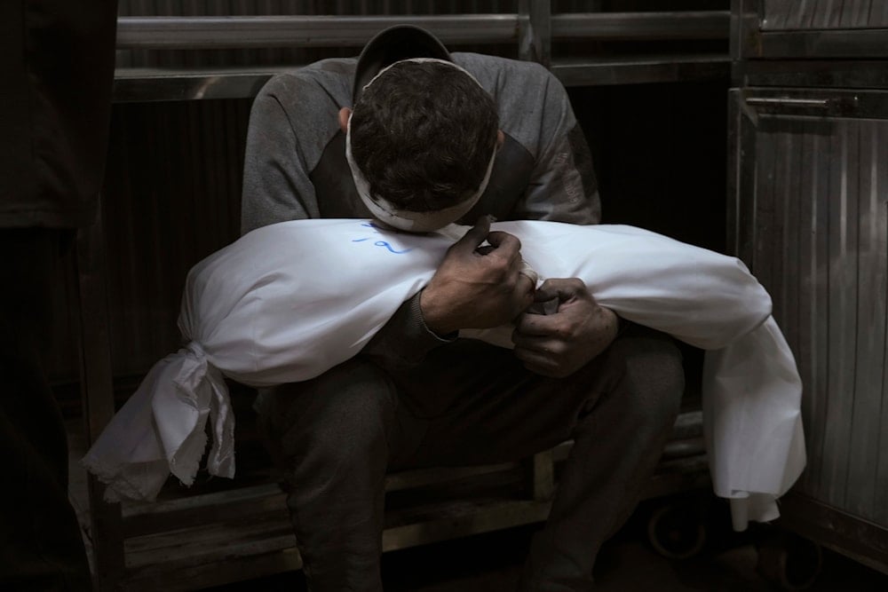  Hossam Azzam holds the body of his child, Amir, who was killed in an Israeli military airstrike on Gaza, at Shifa Hospital in Gaza City Tuesday, July 15, 2025. (AP)