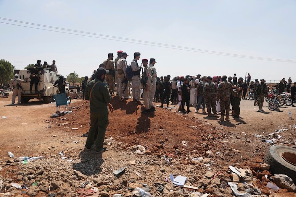 Bedouin fighters, right, gather as Syrian government security forces, left, block them from entering Sweida province, in Busra al-Harir village, southern Syria, Sunday, July 20, 2025 (AP) 