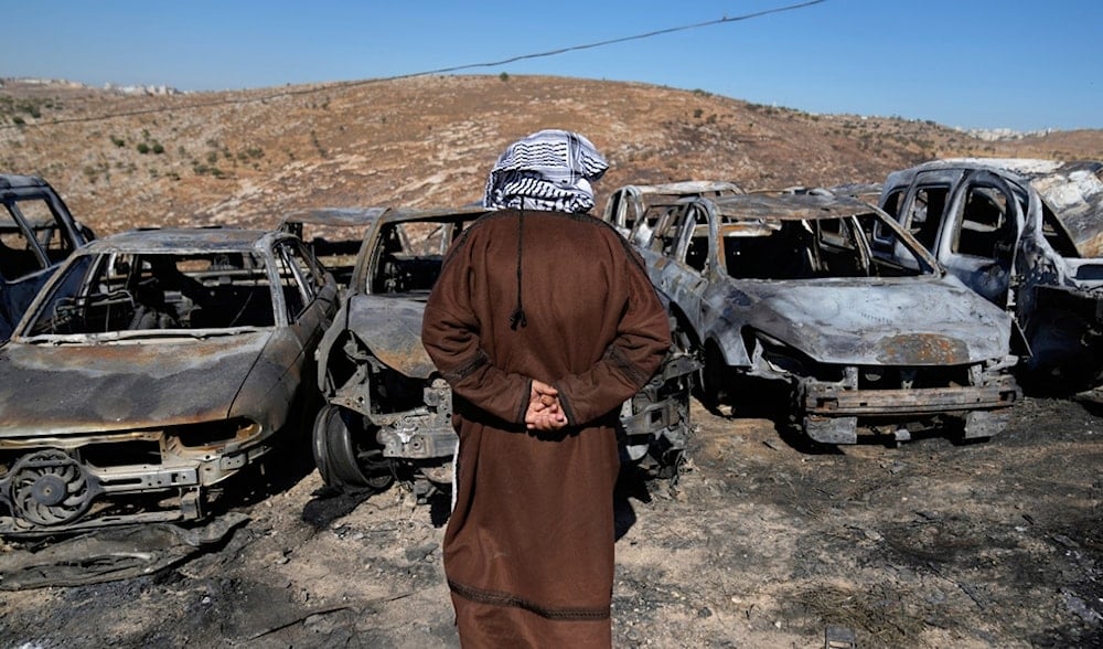 Palestinian landlord Saber Asaleyeh, 74, inspects his scrapyard where vehicles were scorched during an Israeli settler attack overnight in the West Bank village of Burqa, east of Ramallah, July 15, 2025. (AP)