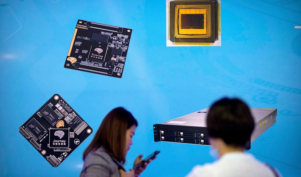 In this May 18, 2018, file photo, visitors walk past a display showing microchips and circuit boards at the 21st China Beijing International High-tech Expo in Beijing.  (AP)
