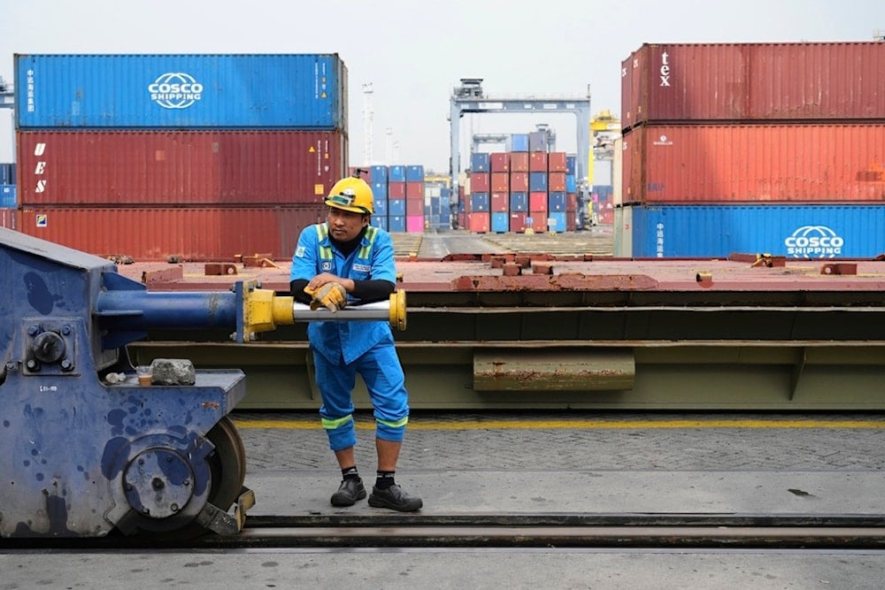 A worker rests during a break as containers are stacked at Jakarta International Container Terminal (JICT) at Tanjung Priok Port in Jakarta, Indonesia, Wednesday, July 9, 2025. (AP)