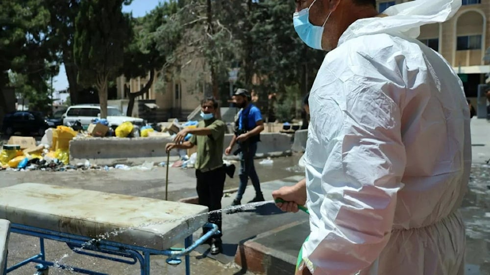 Dated July 20, 2025, a medical worker cleans equipment outside Sweida hospital. (AFP)