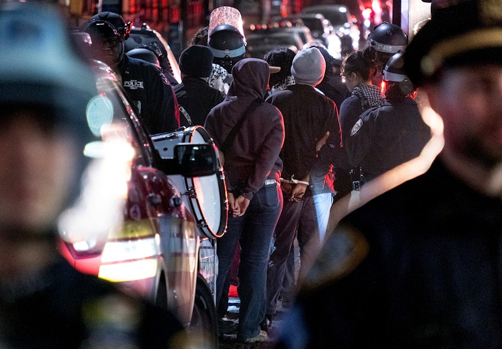 New York City police officers take people into custody near the Columbia University campus in New York Tuesday, April 30, 2024, after a building taken over by protesters earlier in the day was cleared, along with a tent encampment. (AP)