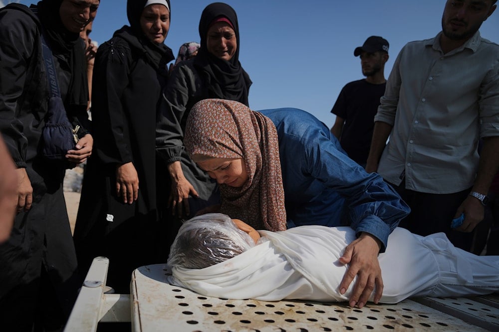 Relatives of Palestinian child Salem Hussein, 12, killed in an Israeli army bombardment of Gaza, mourn beside his body at Shifa Hospital in Gaza City on Tuesday, July 22, 2025 (AP)