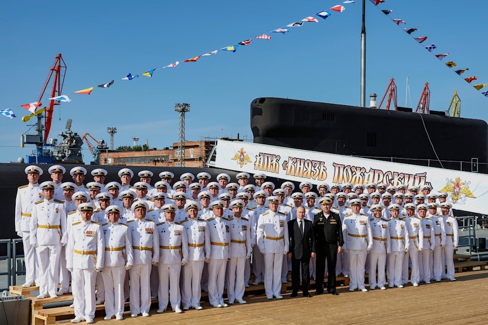 Russian President Vladimir Putin, center, poses for a photo with crew members of the Knyaz Pozharsky Borei-class submarine after a flag raising ceremony in Severodvinsk, Russia, Thursday, July 24, 2025 (AP)