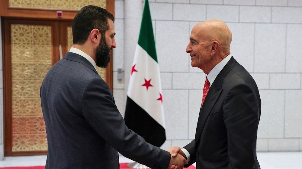 In this photo released by the Syrian official news agency SANA, Syria's interim President Ahmad al-Sharaa, left, shakes hands with U.S. Ambassador to Turkey and Special Envoy to Syria Tom Barrack, in Damascus, Syria on May 29, 2025. (SANA via AP)