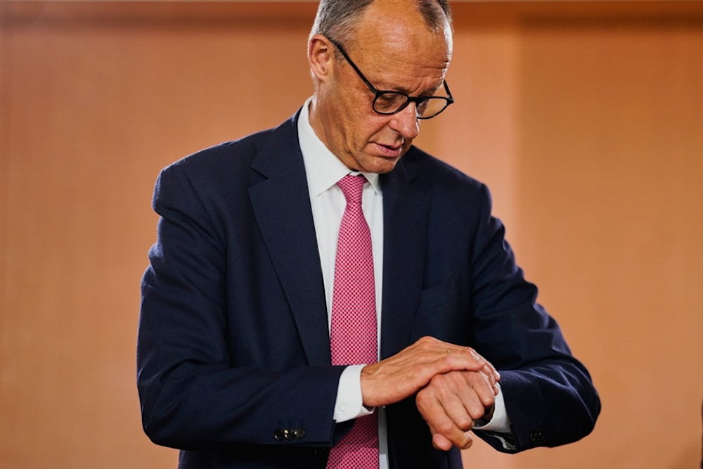 German Chancellor Friedrich Merz looks at his watch as he arrives for the cabinet meeting at the chancellery in Berlin, Germany, Wednesday, July 23, 2025. (AP Photo/Markus Schreiber)