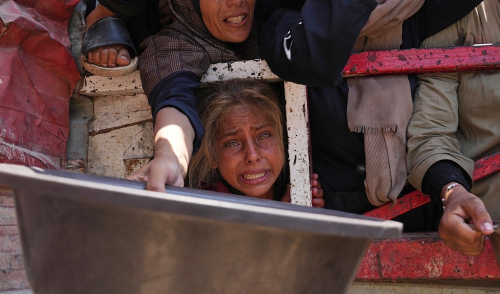 Palestinians struggle to get donated food at a community kitchen, in Gaza City, northern Gaza Strip, Saturday, July 26, 2025. (AP Photo/Abdel Kareem Hana)