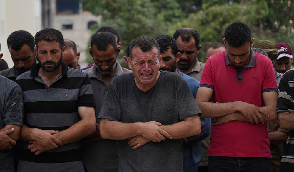 Palestinians pray over the body of a person who was killed while trying to reach aid trucks, at Shifa Hospital, in Gaza City, Saturday, July 26, 2025. (AP)