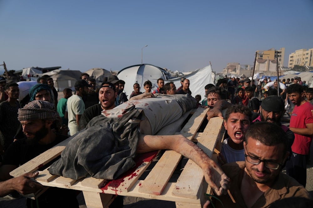 Palestinians carry the body of a man who was hit by a truck while attempting to reach a humanitarian aid convoy that entered Gaza City from the northern Gaza Strip, on July 26, 2025. (AP Photo/Abdel Kareem Hana)