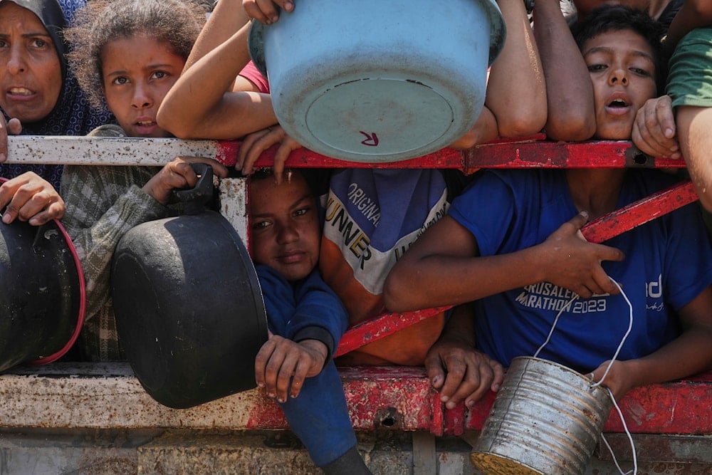 Palestinians struggle to get donated food at a community kitchen, in Gaza City, northern Gaza Strip, on July 26, 2025. (AP Photo/Abdel Kareem Hana)