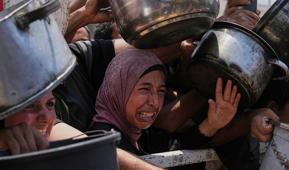 Palestinians struggle to get donated food at a community kitchen, in Gaza City, northern Gaza Strip, Saturday, July 26, 2025. (AP)
