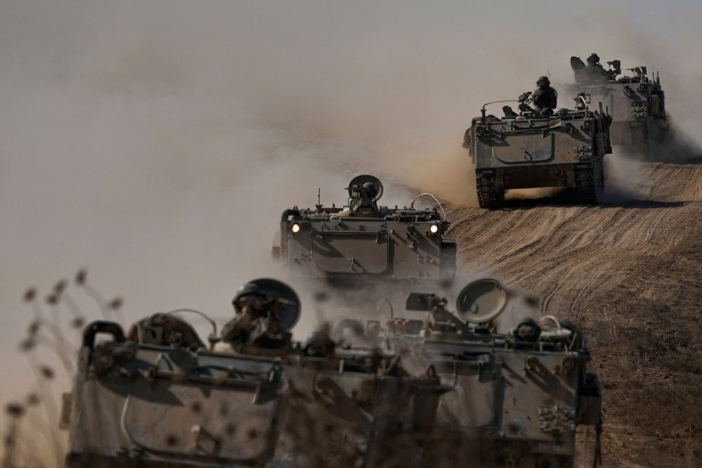 Israeli APCs head towards the Gaza Strip border in southern occupied Palestine on October 13, 2023. (AP)