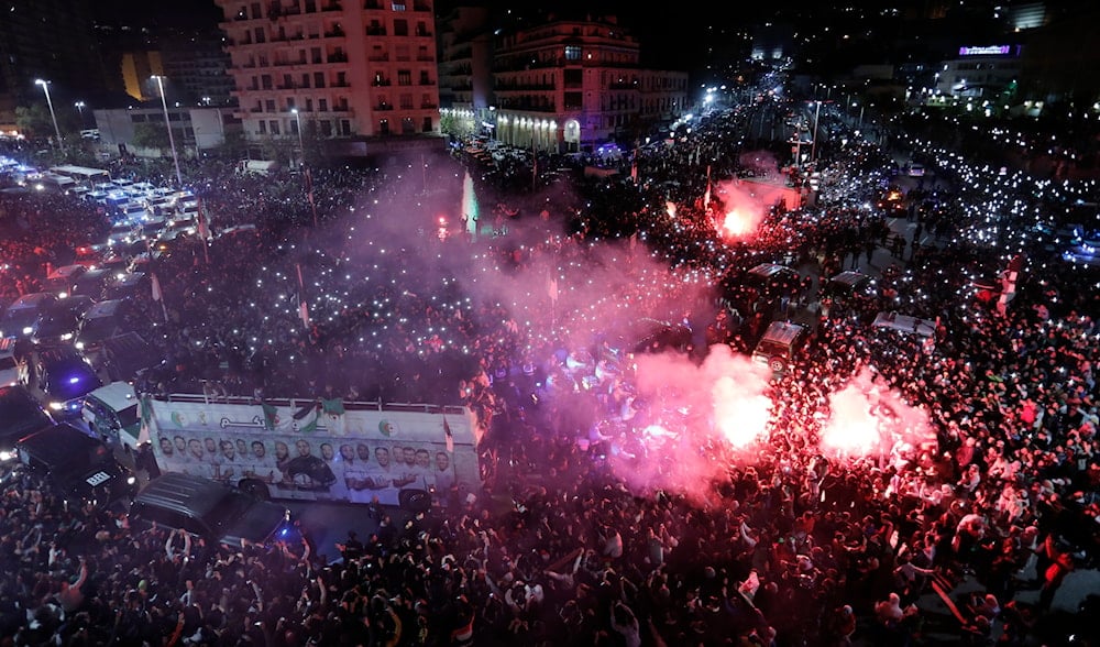 Algeria's national football team members celebrate with the fans during a parade after their win over Tunisia in the final of FIFA Arab Cup 2021 hosted by Qatar, in Algiers, Monday, Dec. 20, 2021. (AP)