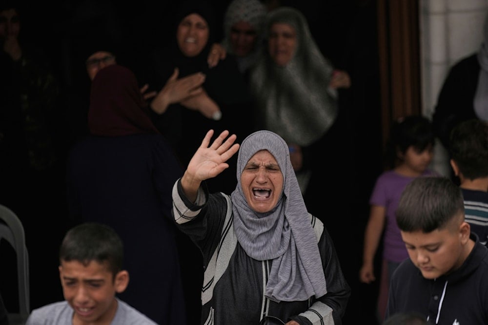 A woman bids farewell to the Palestinian American Khamis Ayyad, 40, who died while trying to extinguish a fire during an Israeli settlers attack, at his funeral in the West Bank village of Silwad, near Ramallah, Friday, August 1, 2025 (AP)