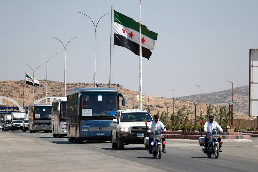 A convoy of buses carrying Syrian refugees who return home from Lebanon, arrives at the Syrian border crossing point in Jdeidet Yabous, Syria, Tuesday, July 29, 2025 (AP)