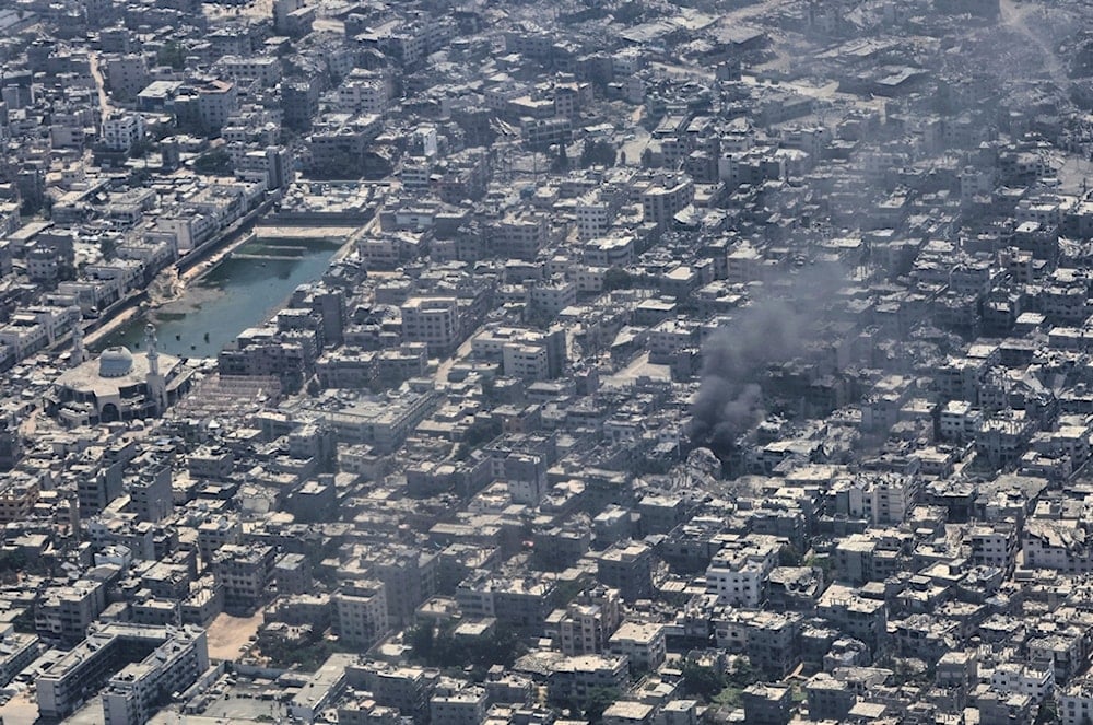 From aboard a Jordanian Air Force C-130, smoke is seen rising from Gaza City during an aid airdrop, Thursday, Aug. 7, 2025 (AP)