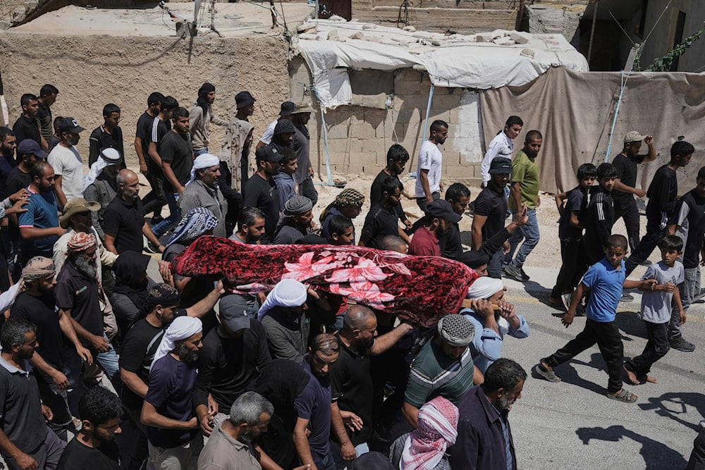 Mourners carry the body of Palestinian activist Awdah Al Hathaleen, who was killed by Israeli settlers, during his funeral in the West Bank Bedouin village of Umm al-Khair, Thursday, Aug. 7, 2025 (AP)