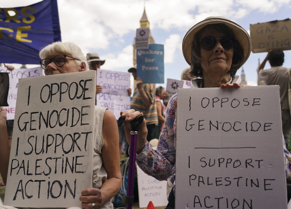 Demonstrators hold placards during a protest in support in support of Palestine in Parliament Square in London on August 9, 2025. (AP)