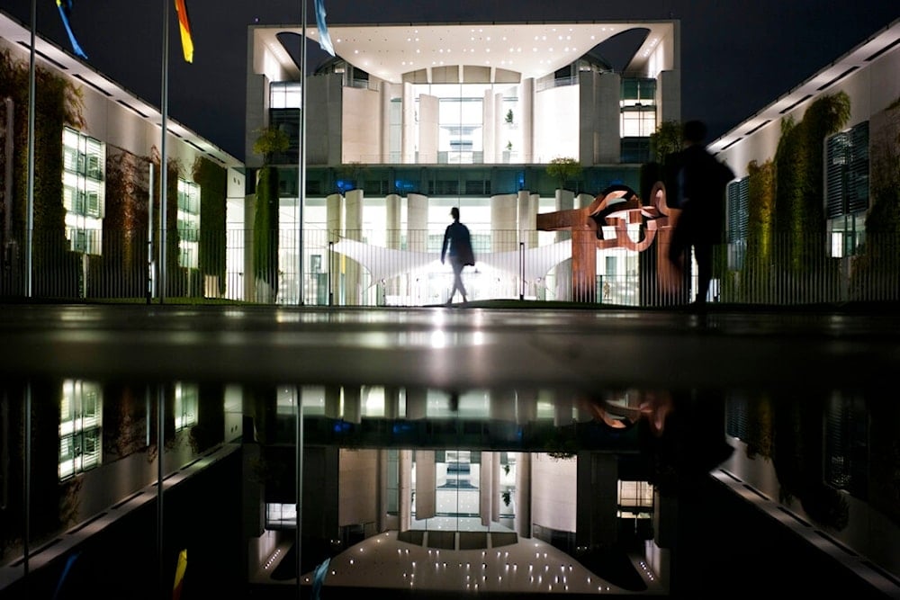 A person walks in front German chancellery in Berlin, Germany, Tuesday, Aug. 25, 2020. (AP)
