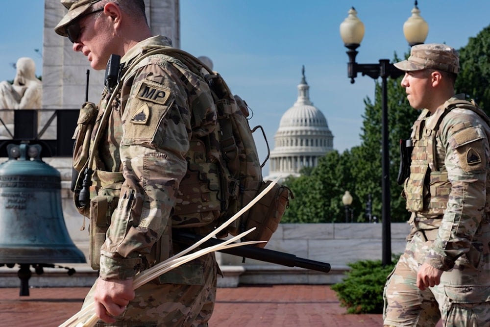 National Guard personnel keep watch as travelers arrive at the entrance to Union Station near the Capitol in Washington, Thursday, Aug. 14, 2025. (AP Photo/J. Scott Applewhite)