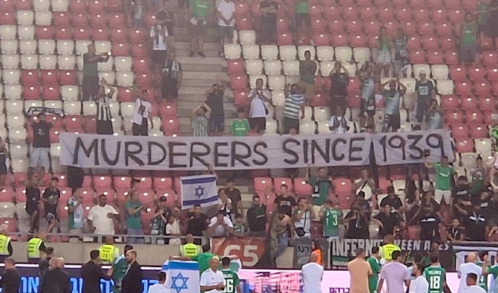 Israeli Maccabi Haifa supporters carry a banner that reads 