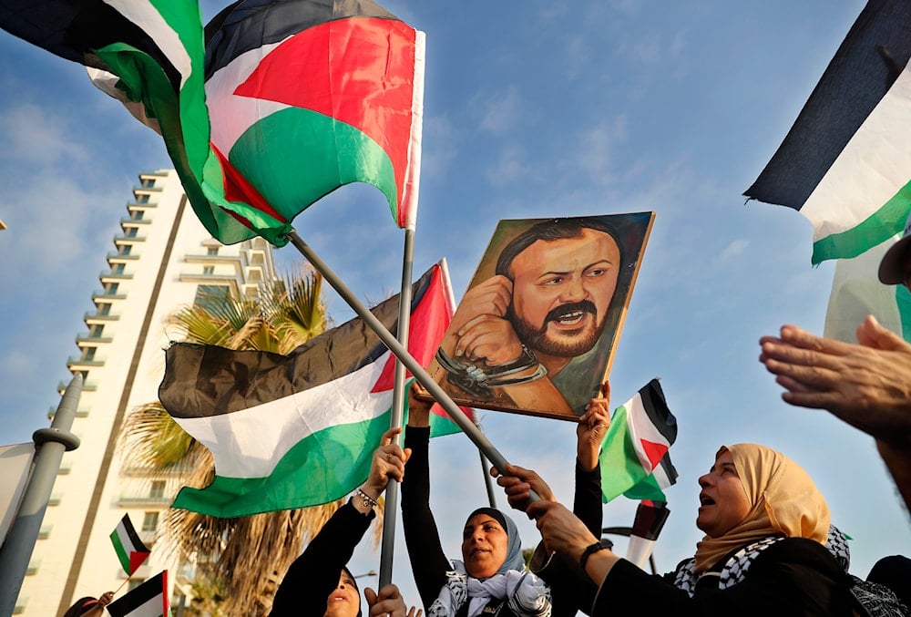 Palestinian women shout slogans while waving their national flags with a picture of jailed leader Marwan Barghouti, during a protest in Beirut, Lebanon, on May 4, 2017 (AP)