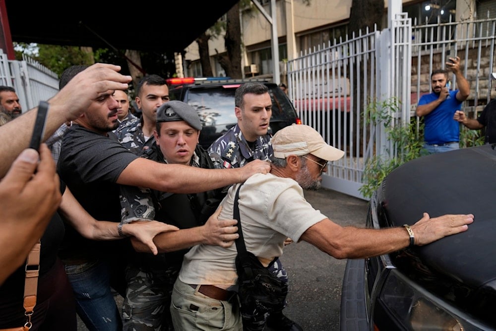 Protesters confront the police convoy transporting Riad Salameh, the former governor of Lebanon's Central Bank, upon his arrival at the court building in Beirut, Lebanon, Monday, September 9, 2024 (AP)