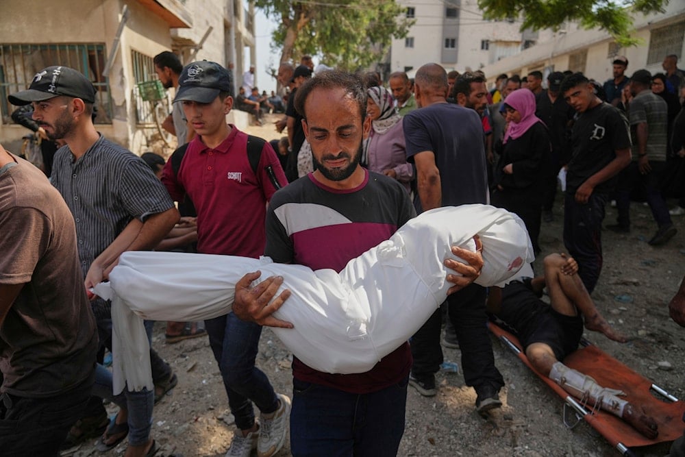 A Palestinian man carries the body of his 7-year-old nephew, Alaa Al-Toum, who, according to the family, was killed in an Israeli army airstrike last night, during his funeral at Shifa Hospital in Gaza City, Saturday, Aug. 16, 2025 (AP)