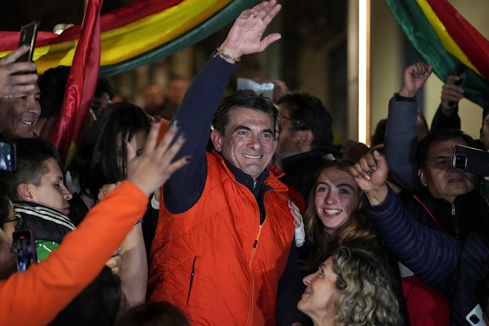 Presidential candidate Rodrigo Paz, center, waves to supporters after early results showed him leading in the presidential election in La Paz, Bolivia, Sunday, on August 17, 2025. (AP Photo/Natacha Pisarenko)
