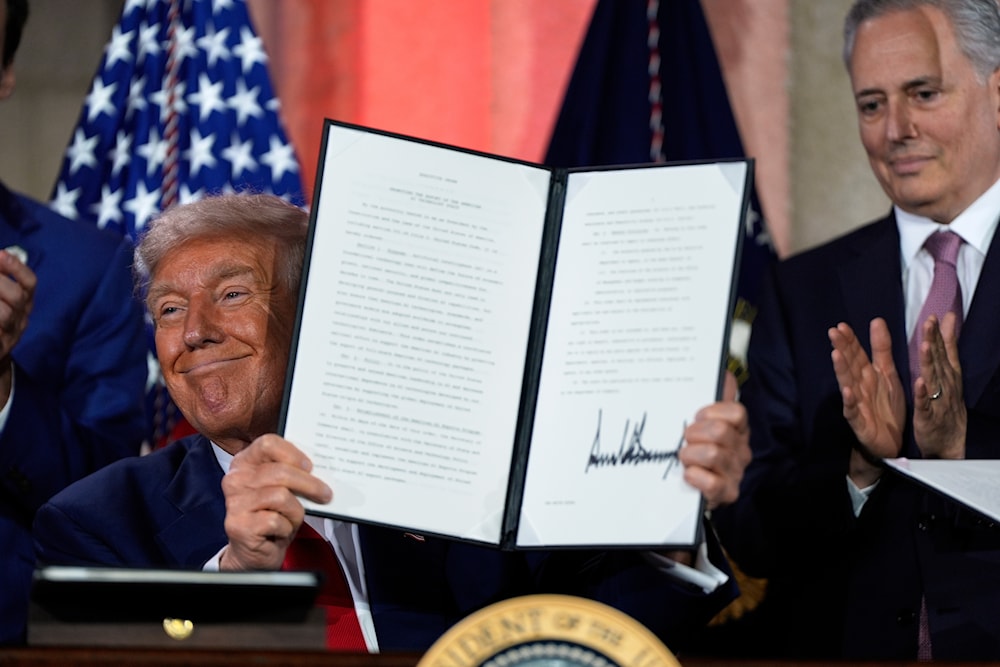 President Donald Trump holds a signed executive order after speaking during an AI summit at the Andrew W. Mellon Auditorium, Wednesday, July 23, 2025, in Washington (AP)